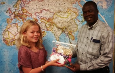 Every little thing makes a difference. Even this zip-locking plastic bag will be a blessing to the family that receives it. Pictured: Paige presenting a Christmas Gift Bag to Pastor Louinet of Haiti.